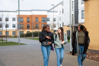 Three female undergraduate students walking together on campus